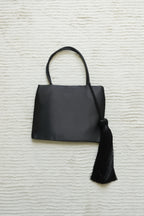Minimalist Black Nylon Top Handle Bag with Statement Silk Tassel Accent